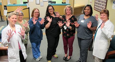 Amanda Reynolds, FNP, Renee McCluskey, Wendy Perretta, Amanda Northcutt, Trish Beatini, Lanette Smith, and Dawn Sampson, PA-C—some of the staff at Dosher Medical Plaza—give the “10-year” hand sign to mark the anniversary of the first Dosher Medical clinic.