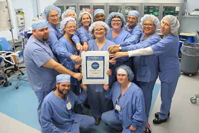 Thirteen members of the Dosher Operating Room team pose with the award from AORN for eradicating surgical smoke.