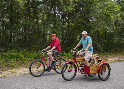 Charlie Rollins and son Mark Rollins with dog Sydney on a health ride at Oak Island.